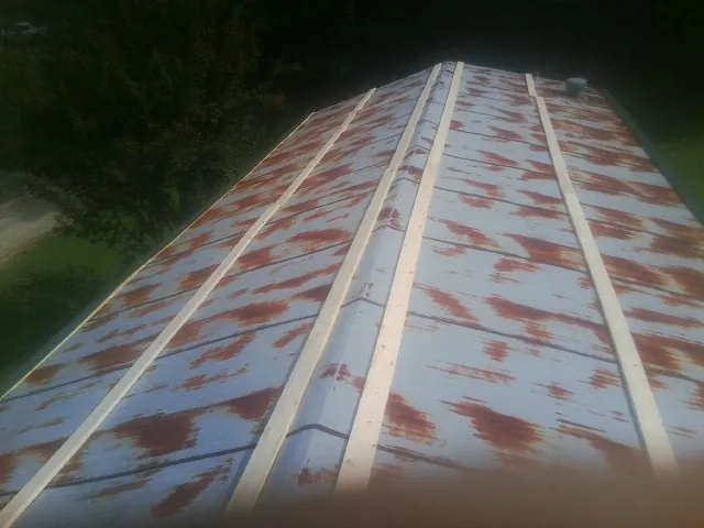 Rusted metal roof panels with new wood purlins before replacement — Storm Damage Roof Repair in Pinola by Roofing Brothers