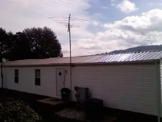 New metal roof on a single wide mobile home with a TV antenna in Pinola