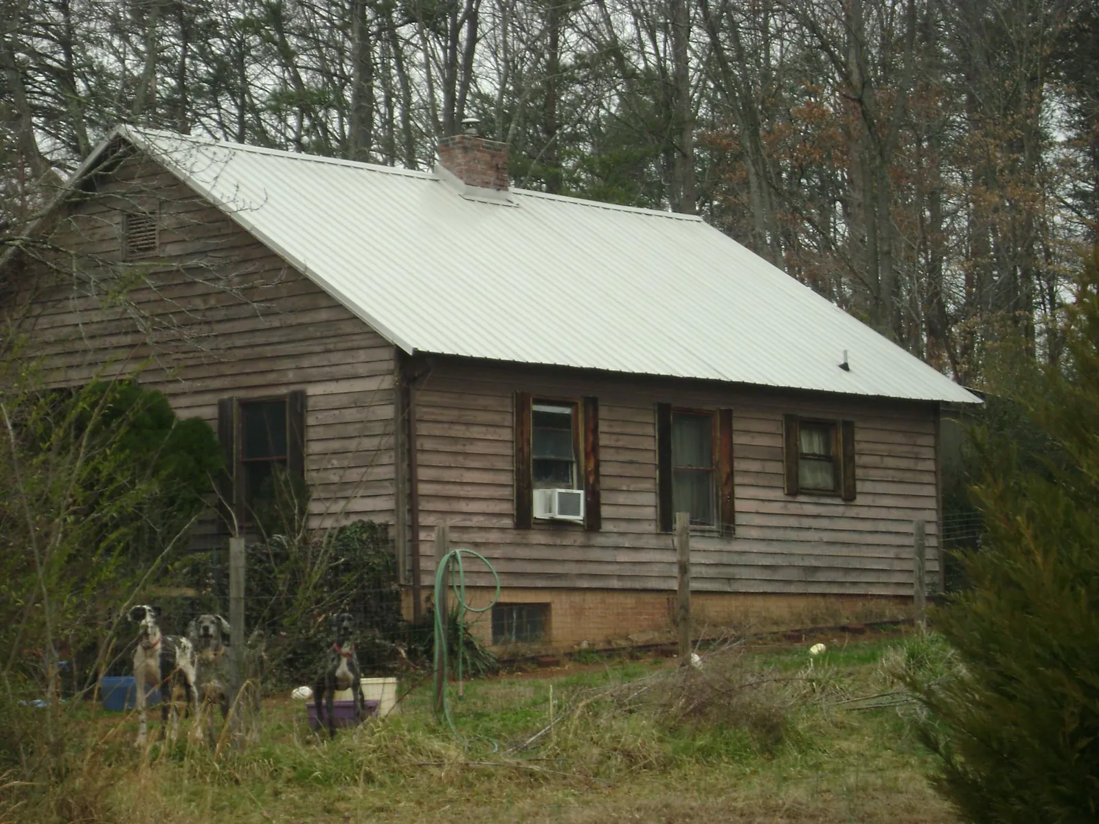 White metal roof on an old wood sided farmhouse, from a Metal Roof Installation job in Pinola